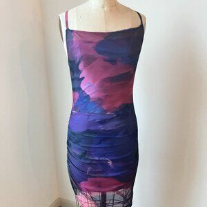 Striking ruched mesh bodycon dress in vibrant purple + cobalt tones.